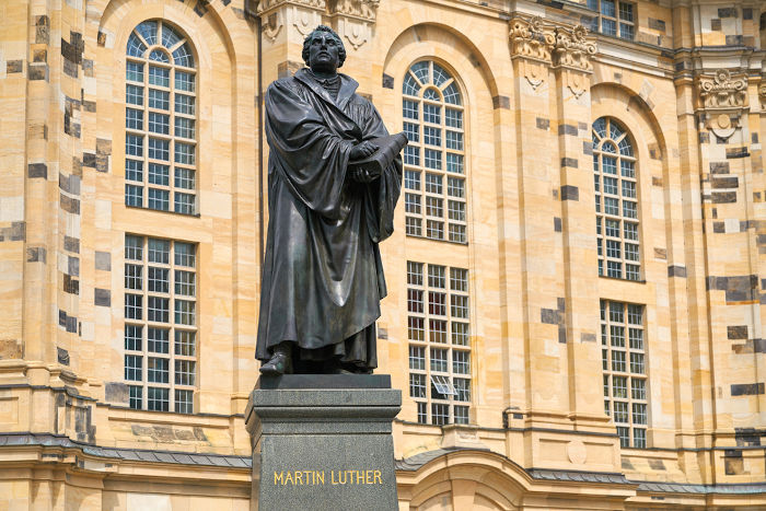 Estátua de Lutero localizada em Frauenkirche. O reformador é representado segurando a Bíblia, pois foi ele quem a traduziu do grego para o alemão. [1]