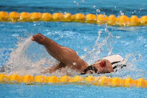 Nadador paralímpico nadando na piscina.