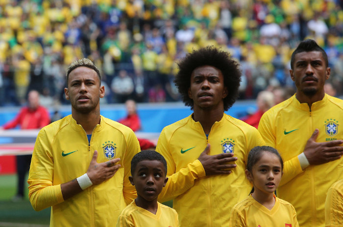 Jogadores da Seleção Brasileira de Futebol cantando o Hino Nacional.