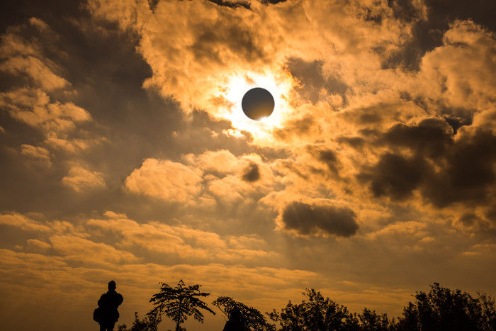 Ocorrência de um eclipse solar, com a Lua bloqueando a luz do Sol.