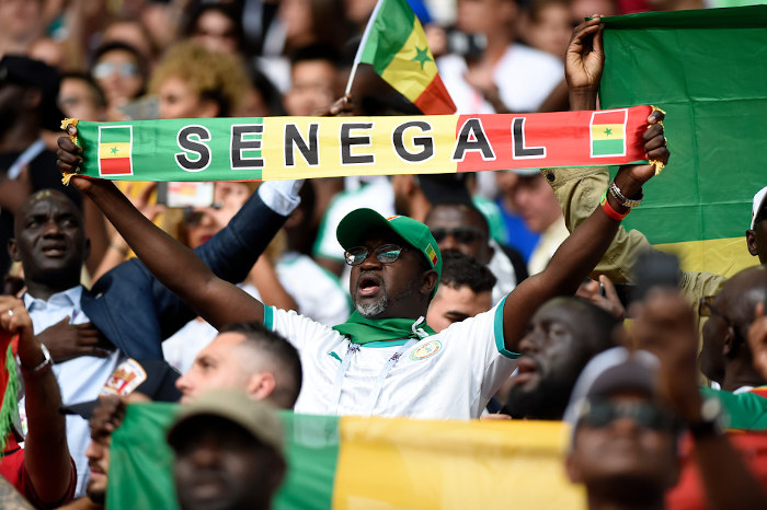 Torcedor senegalês em estádio de futebol em meio à torcida