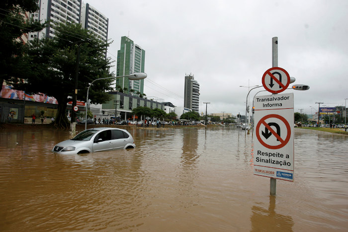 Carro em área urbana afetada por enchente.