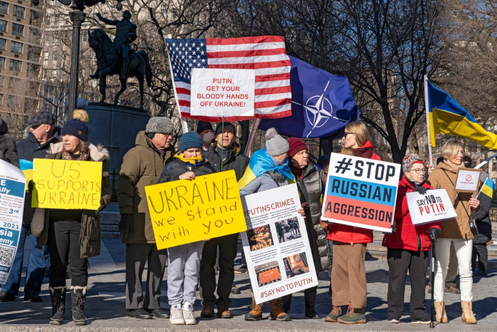 Pessoas segurando cartazes e bandeiras em comício na Union Square em meio à ameaça de invasão russa da Ucrânia.