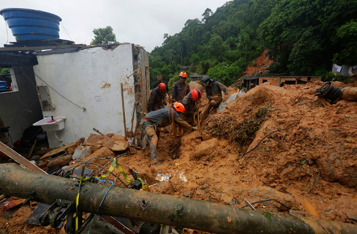 Equipe de resgate procura vítimas de um deslizamento de terra causado por fortes chuvas em São Paulo.