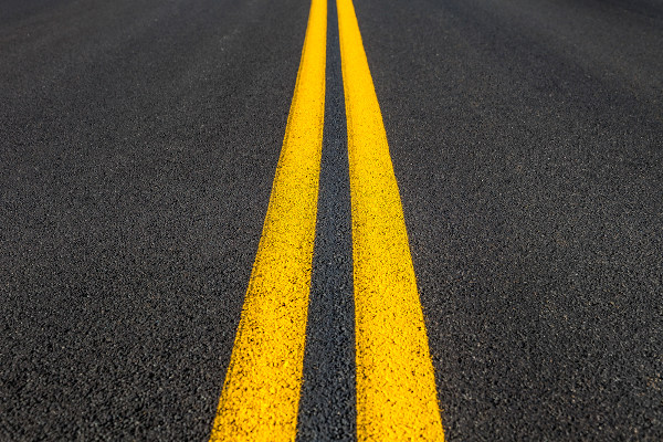 Faixas amarelas em estrada representando retas paralelas