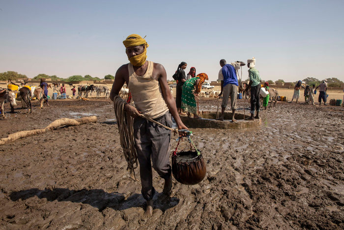 Um homem carregando água do poço para seu camelo, em Abeche, no Chade.