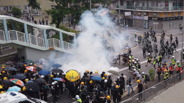 Policiais lançando gás lacrimogêneo para dispersar manifestantes que participavam de protestos em Hong Kong, em 2019. [1]