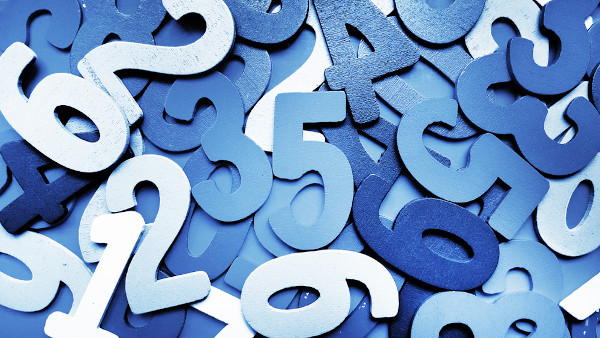 Vários números, em diferentes tons de azul, dispostos uns sobre os outros em uma superfície plana.