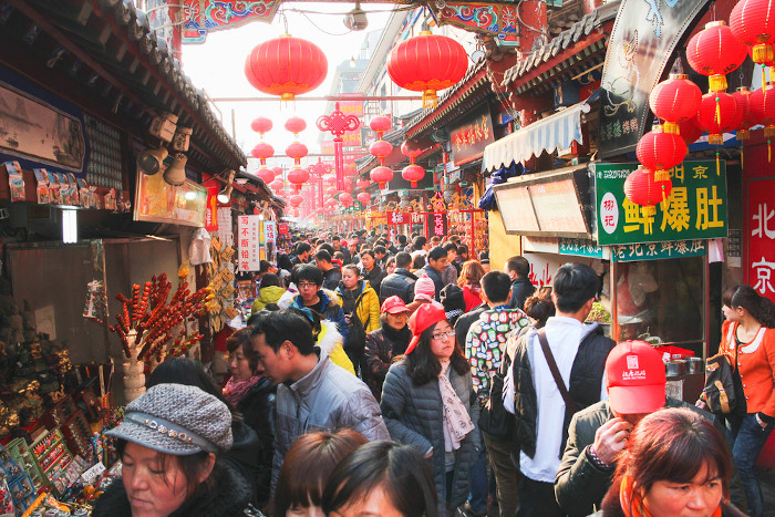Multidão em uma rua comercial de Pequim, na China.