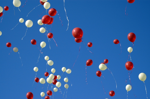 Vista inferior de vários balões preenchidos com gás hélio no céu.