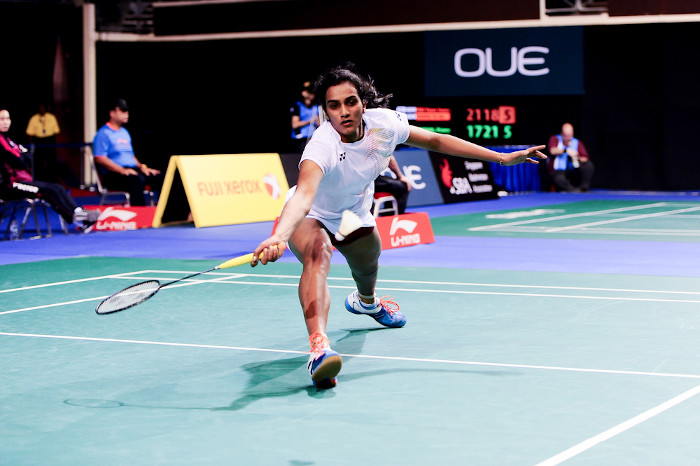 Atleta indiana em competição de badminton, em momento de recepção da peteca. [1]