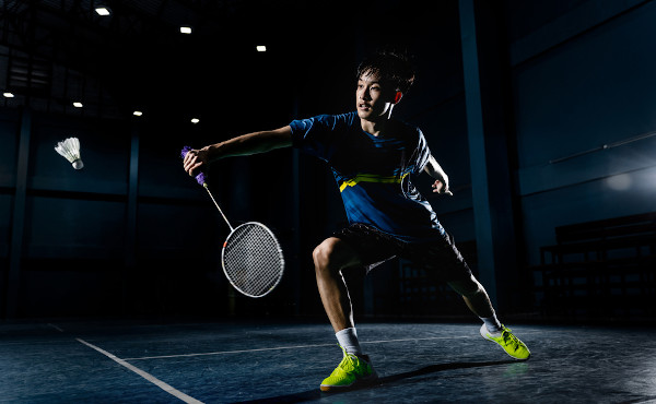 Atleta preparado para receber a peteca no badminton.