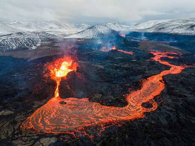  Lava sendo expelida por um vulcão: o lançamento do magma, que antes estava no manto terrestre, na superfície terrestre.