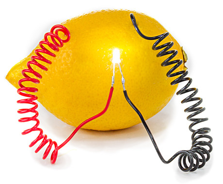 Pequena lâmpada acesa por meio de fios elétricos fincados em limão.