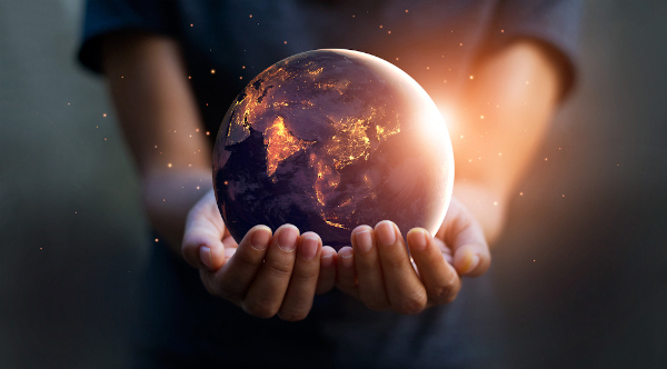 Representação gráfica de uma pessoa segurando o planeta Terra nas mãos como representação da Nova Ordem Mundial.