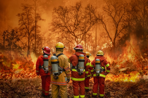Bombeiros diante de incêndio florestal, um efeito do aquecimento global.