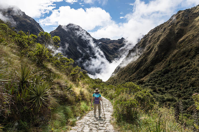 Mulher percorrendo a trilha inca, no Peru.