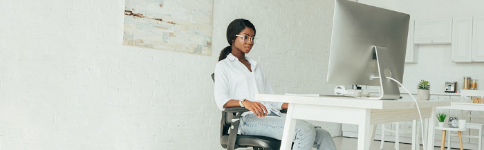 Fotografia de uma jovem sentada trabalhando usada em uma questão sobre “do” e “does”.
