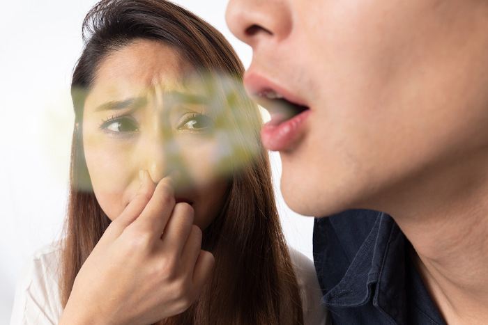 Mulher tampa nariz enquanto homem solta hálito malcheiroso, em referência ao hálito de telúrio.