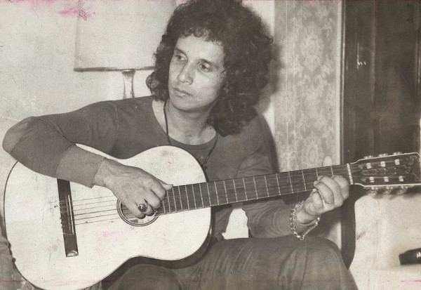Jovem cantor Roberto Carlos, símbolo da Jovem Guarda, tocando violão.