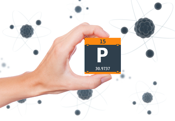 Pessoa segurando um cubo preto com laranja com o símbolo, o número atômico e a massa do elemento químico fósforo.