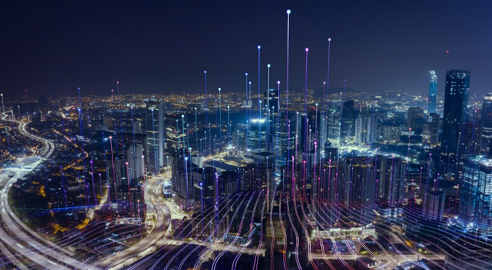 Vista panorâmica noturna de luzes nas vias de uma cidade, representando fluxos, um conceito da Geografia econômica.