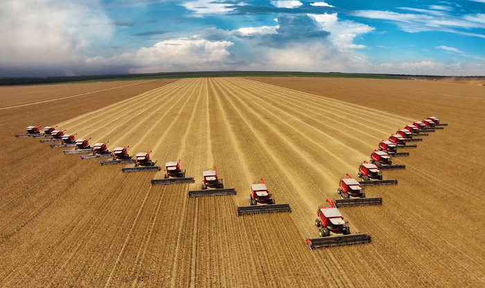 Máquinas agrícolas em um grande campo de soja.