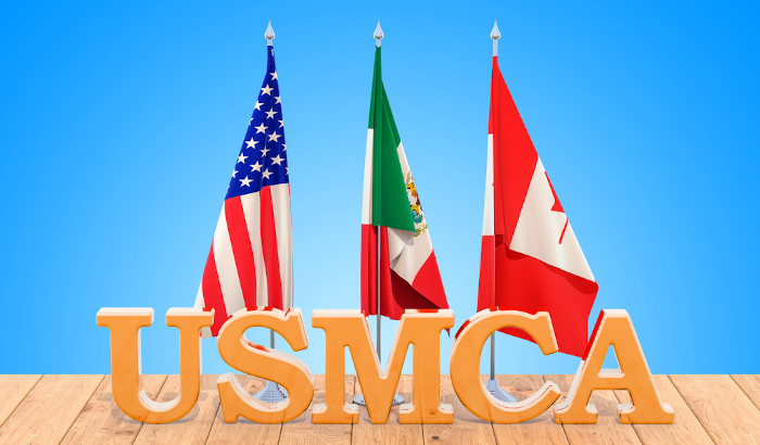 Bandeiras dos EUA, Canadá e México atrás da sigla USMCA.