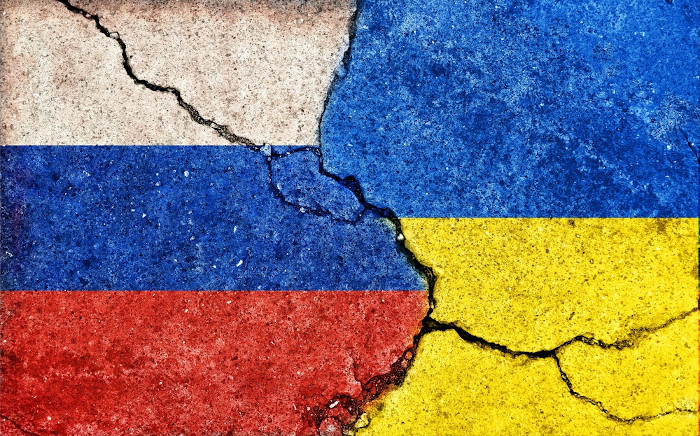  Representação gráfica da guerra entre Rússia e Ucrânia, com as bandeiras dos países pintadas em concreto com rachaduras.