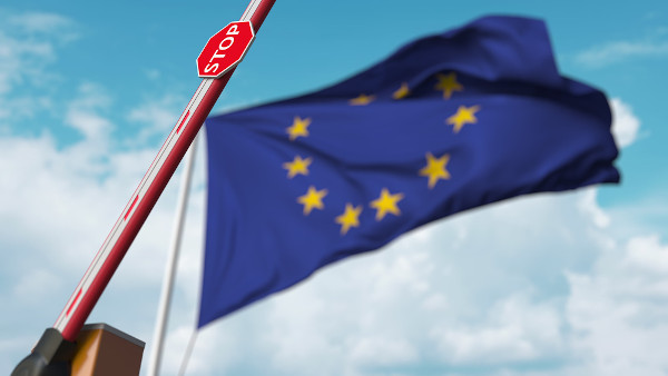 Bandeira da União Europeia e uma barreira alfandegária em alusão à união aduaneira.