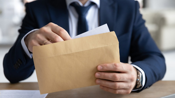 Homem abrindo uma correspondência como representação do ofício.