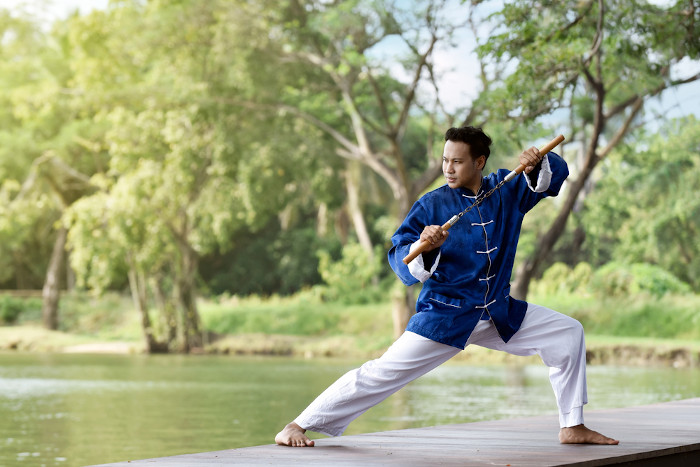  Homem segurando uma matraca, instrumento da prática de kung fu, uma das principais artes marciais.