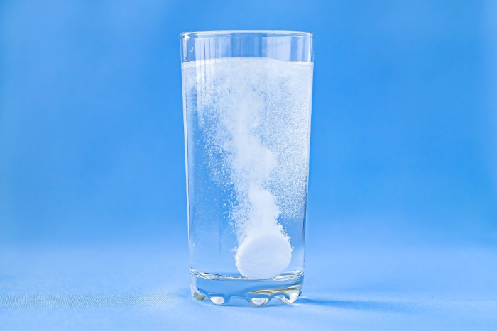 Transformação química evidente pela liberação de gás em copo com água e antiácido.