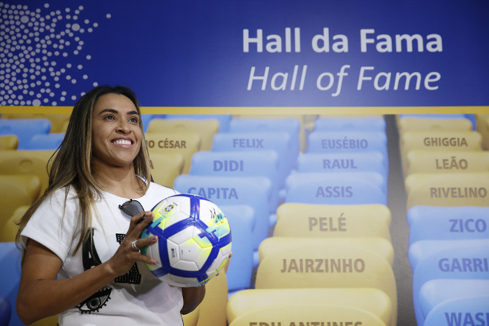 Marta, uma das principais atletas da Copa do Mundo Feminina, segurando uma bola de futebol no Estádio Maracanã.