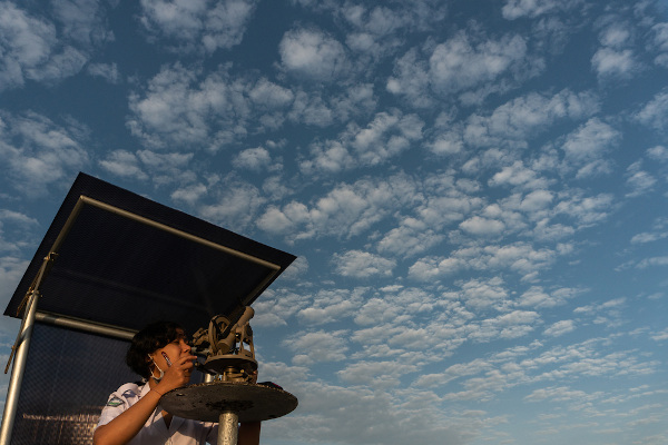 Meteorologista manuseando um equipamento usado para fazer a previsão do tempo.