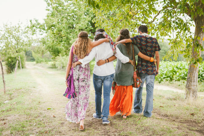 Quatro jovens utilizando roupas características do movimento hippie.