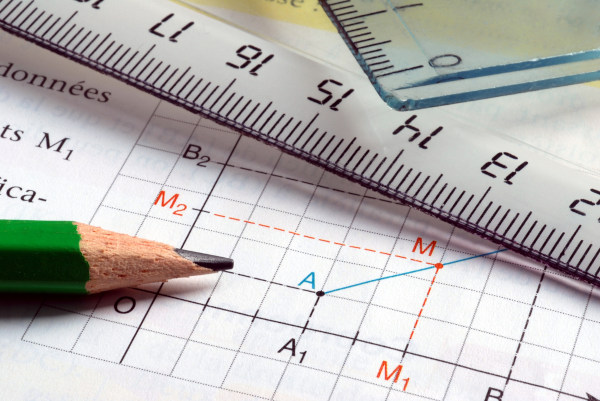 Lápis sobre coordenadas em um papel, em alusão à Geometria Analítica.