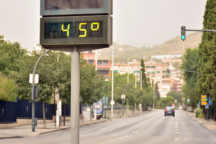 Grande termômetro em ambiente urbano registrando temperatura de 45 °C.