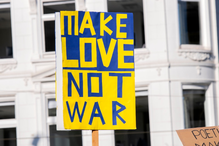 Placa com o escrito “Make love, not war”, frase do movimento hippie, em manifestação contra a Guerra entre Rússia e Ucrânia.