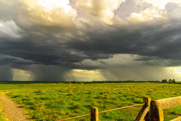 Tempestade formada em nuvens cumulunimbus acontecendo em terras agrícolas.