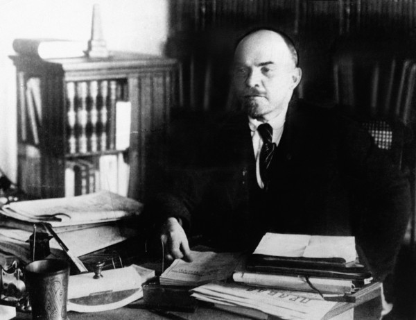 Vladimir Lenin, líder da Revolução Russa, sentado diante de sua mesa.