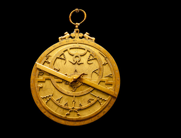Astrolábio em um fundo preto, instrumento de navegação antigo que foi muito utilizado no período das Grandes Navegações.