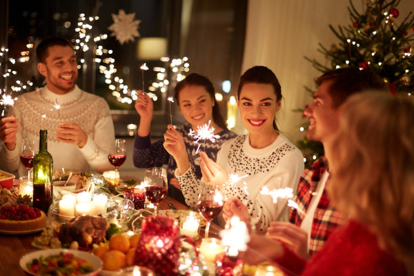 Pessoas sentadas em mesa celebrando o Natal.