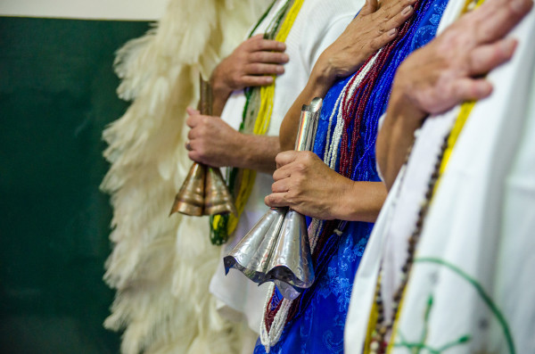 Três pessoas com trajes da umbanda.