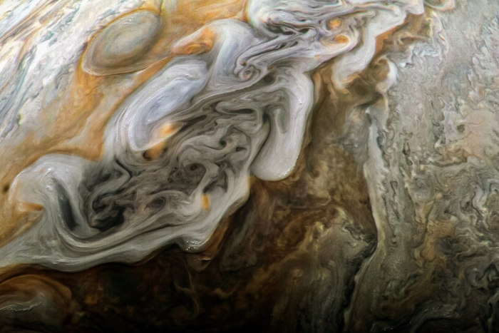 A superfície de Júpiter é gasosa, composta principalmente por elementos como hélio e hidrogênio.