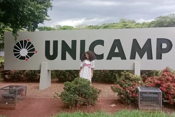 Angélica Toledo está próximo ao letreiro da Unicamp