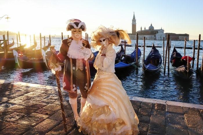 Casal com máscaras e trajes típicos em comemoração de Carnaval em Veneza, na Itália.
