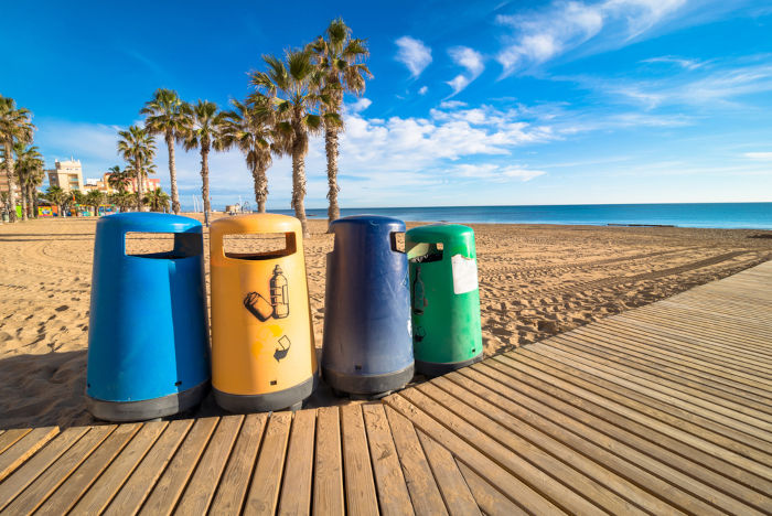 Lixeiras seletivas em uma praia, um dos meios para solucionar a poluição marinha.