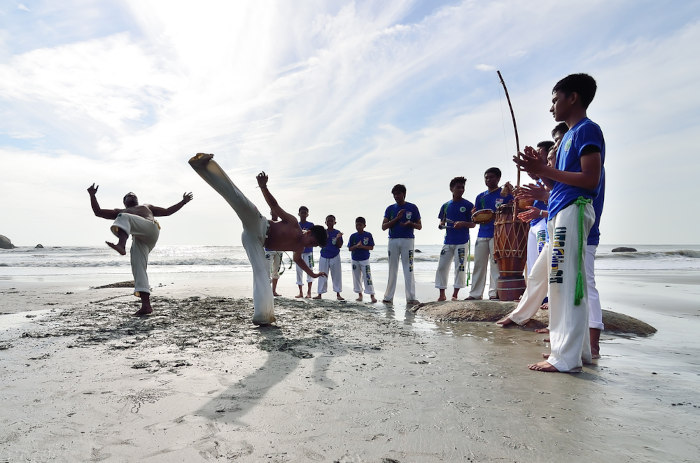 Roda de capoeira na praia, exemplo de patrimônio cultural imaterial do Brasil.