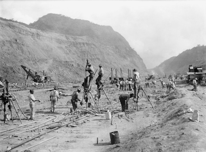 Trabalhadores escavando o solo durante a construção do canal do Panamá.